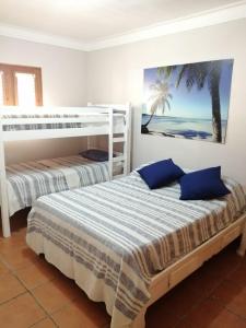 a bedroom with two beds with blue pillows at Apartamento amueblado en Juan Dolio in La Puntica de Juan Dolio