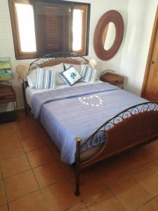 a bedroom with a large bed with a blue blanket at Apartamento amueblado en Juan Dolio in La Puntica de Juan Dolio
