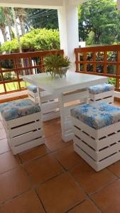 a white table and two stools on a porch at Apartamento amueblado en Juan Dolio in La Puntica de Juan Dolio
