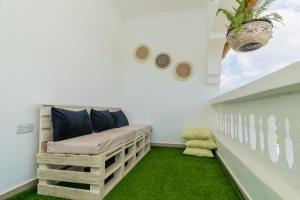 a bench in a room with green grass at Chameleon house diani in Ukunda