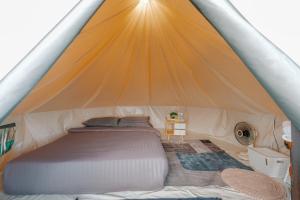 a bed inside of a tent at ฮิมสวน โฮมสเตย์ Him suan homestey in Ban Thung Phan Ha