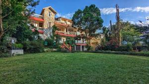 a large building with a lawn in front of it at Shikher in Kalimpong