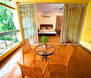 アンジュナにあるAtulyam Villa- Anjunaのリビングルーム(テーブル、椅子、ベッド付)