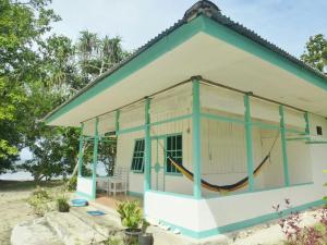 uma pequena casa com uma rede em frente em Scuba Republic Beach Bungalows em Tapokreng