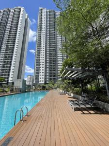 ein Pool mit Bänken und einige hohe Gebäude in der Unterkunft Hidden Gem Bali Stays in KL in Kuala Lumpur