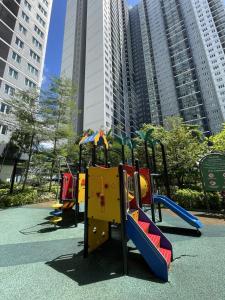 une aire de jeux avec toboggan dans un parc avec de grands bâtiments dans l'établissement Hidden Gem Bali Stays in KL, à Kuala Lumpur