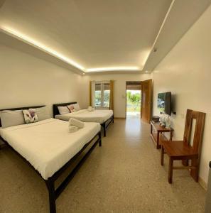 pokój hotelowy z 2 łóżkami i telewizorem w obiekcie 모알보알 트리쉐이드 w mieście Moalboal