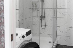 La salle de bains est pourvue d'une douche et d'un lave-linge. dans l'établissement RentWill apartments Diplomat, à Chişinău