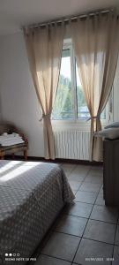 a bedroom with a bed and a window with curtains at Parri 33 Bologna Fiera 4+1 Guest Parking on demand in Bologna