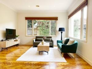 a living room with two couches and a tv at Brighton Golden Mile in Melbourne
