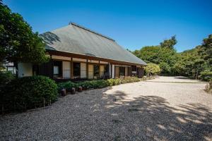 une maison avec une allée en gravier en face de celle-ci dans l'établissement 甘糟屋敷 Amakasu Yashiki KAMAKURA, à Kamakura