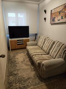sala de estar con sofá y TV de pantalla plana en Flat in Castellon, en Castellón de la Plana