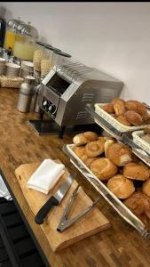 a counter with a bread machine and a pile of bagels at Spirit of Herzl Hotel in Jerusalem