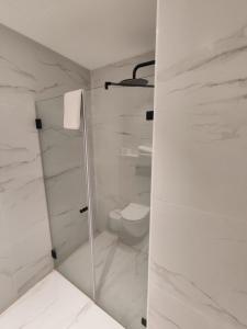 a white bathroom with a shower and a toilet at Spirit of Herzl Hotel in Jerusalem