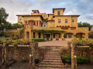 a large house with stairs in front of it at Castello Di Monte in Pretoria