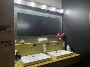 a bathroom with two sinks and a large mirror at HARE-TABI SAUNA&INN Yokohama in Yokohama