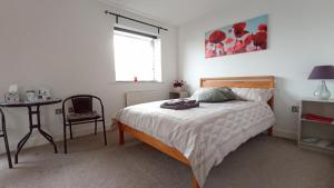 1 dormitorio con cama, mesa y ventana en Arena House, en Mánchester