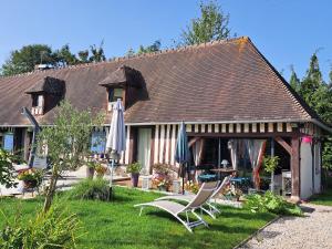 a house with two chairs and umbrellas in the yard at Léalie in Gonneville-sur-Honfleur