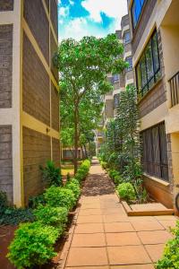 un callejón entre dos edificios con árboles y plantas en Belaire BnB Syokimau, en Nairobi