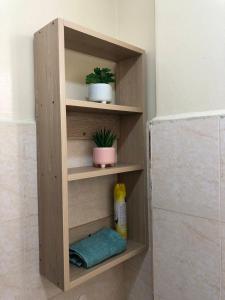 un estante de madera en un baño con dos plantas en Belaire BnB Syokimau, en Nairobi