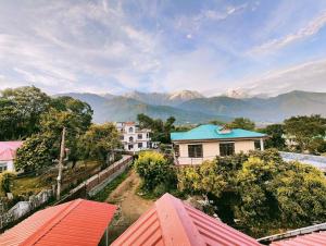einen Blick auf ein Haus mit Bergen im Hintergrund in der Unterkunft Aviator's Bungalow - Dharamshala in Dharamshala
