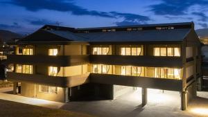 um grande edifício com janelas iluminadas à noite em Resort Yufuin - Grandpia Resort Yufuin em Yufu