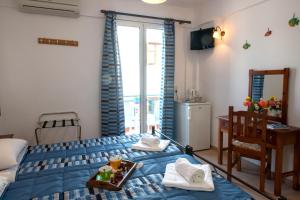 a bedroom with a bed with a tray of food on it at Hotel Kyma in Skala Eresou