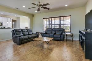 a living room with leather furniture and a ceiling fan at McKinney Home with Backyard, 10 Mi to Dtwn! in McKinney