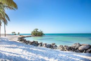 a beach with a bunch of rocks and the ocean at 4BR Sombrero Beach House on Canal w Dock & Pool in Marathon