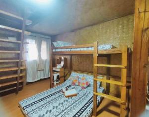 1 Schlafzimmer mit 2 Etagenbetten und einem Tisch in der Unterkunft El Nido Backpackers Guesthouse in El Nido