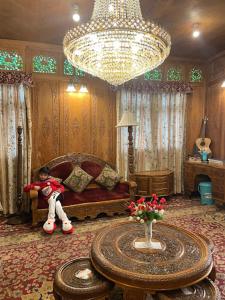 ein Wohnzimmer mit einem Sofa und einem Kronleuchter in der Unterkunft Houseboat Kashmir Treat in Srinagar