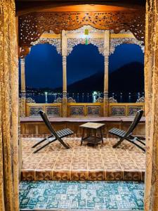 eine Bühne mit einem Tisch und Stühlen auf einem Balkon in der Unterkunft Houseboat Kashmir Treat in Srinagar