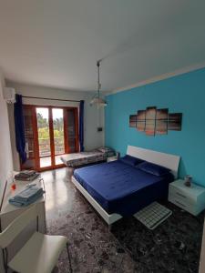 a bedroom with a bed and a blue wall at Casa Sonia in Porto Pino