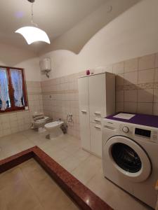 a bathroom with a washing machine and a toilet at Casa Sonia in Porto Pino