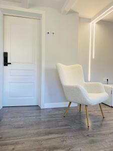 uma cadeira branca sentada num quarto com uma porta em Express Inn em Poti