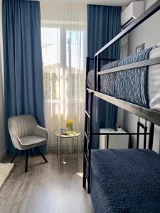 Express Inn في بوتي: غرفة نوم بسريرين بطابقين وكرسي ونافذة
