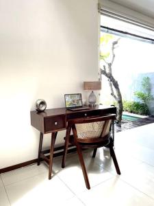 einen Schreibtisch in einem Zimmer mit einem Stuhl und einem Fenster in der Unterkunft The Samya Villa, Berawa Canggu in Denpasar