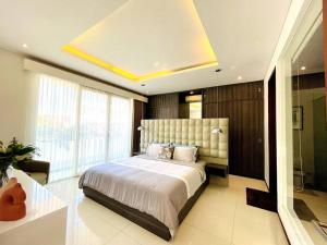 ein Schlafzimmer mit einem großen Bett und einem großen Fenster in der Unterkunft The Samya Villa, Berawa Canggu in Denpasar