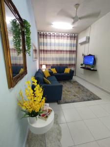セパンにあるBunga Homestay KLIA Sepangの青いソファとテレビのあるリビングルーム