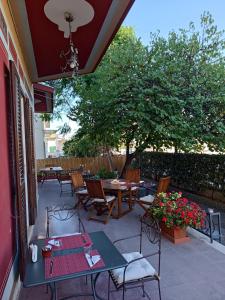 a patio with tables and chairs and a tree at B&B De Angelis in Ginosa Marina