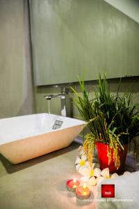 a bathroom with a sink with flowers and candles at Chillies Grand by Lathpandura, Polonnaruwa in Polonnaruwa