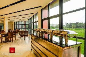 a dining room with chairs and tables and windows at Chillies Grand by Lathpandura, Polonnaruwa in Polonnaruwa