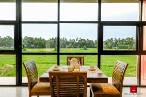 ポロンナルワにあるChillies Grand by Lathpandura, Polonnaruwaのダイニングルーム(テーブル、椅子付)、大きな窓が備わります。