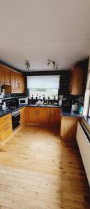 a kitchen with wooden cabinets and a wooden floor at Fox Lodge in Drogheda