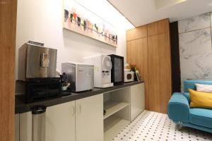 una cocina con electrodomésticos en una encimera con una silla azul en H Avenue Hotel Minam en Busan