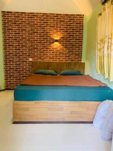 a bed in a room with a brick wall at cher lonely beach resort Koh chang in Ko Chang