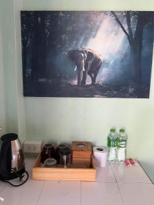 a painting of an elephant on a wall next to a table at cher lonely beach resort Koh chang in Ko Chang