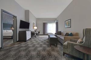 um quarto de hotel com um sofá e uma cama e uma televisão em Four Points by Sheraton Birmingham Homewood em Homewood