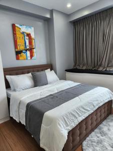 マニラにあるCozy and Spacious Condo Unit with Free Netflixの大きなベッド付きのベッドルーム1室、壁に絵画が飾られています。