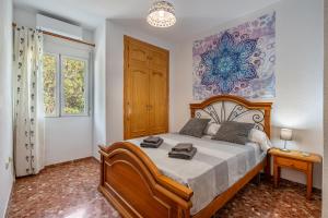 a bedroom with a bed and a painting on the wall at Amplio apartamento en Güejar Sierra in Güéjar-Sierra